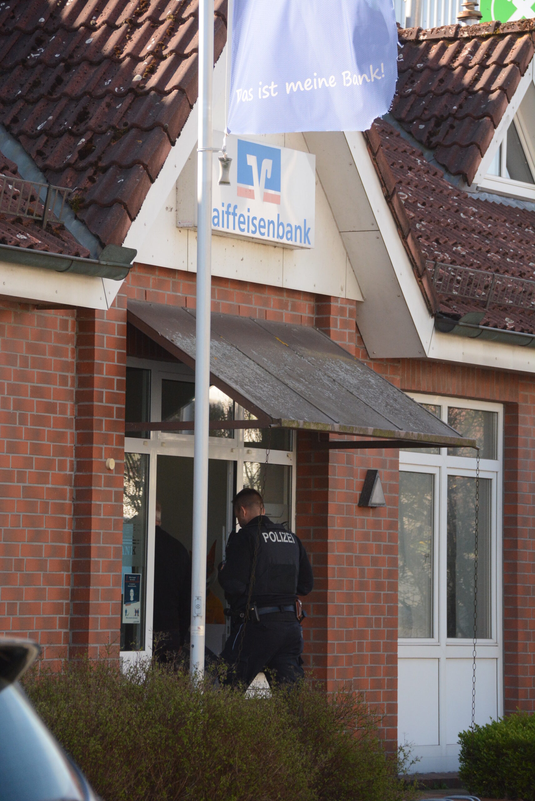 Ein Polizist geht in die eingebrochene Bank in Müssen (Kreis Herzogtum Lauenburg).