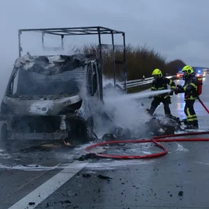 Feuerwehrkräfte löschen den in Flammen aufgegangen Transporter auf der A1.