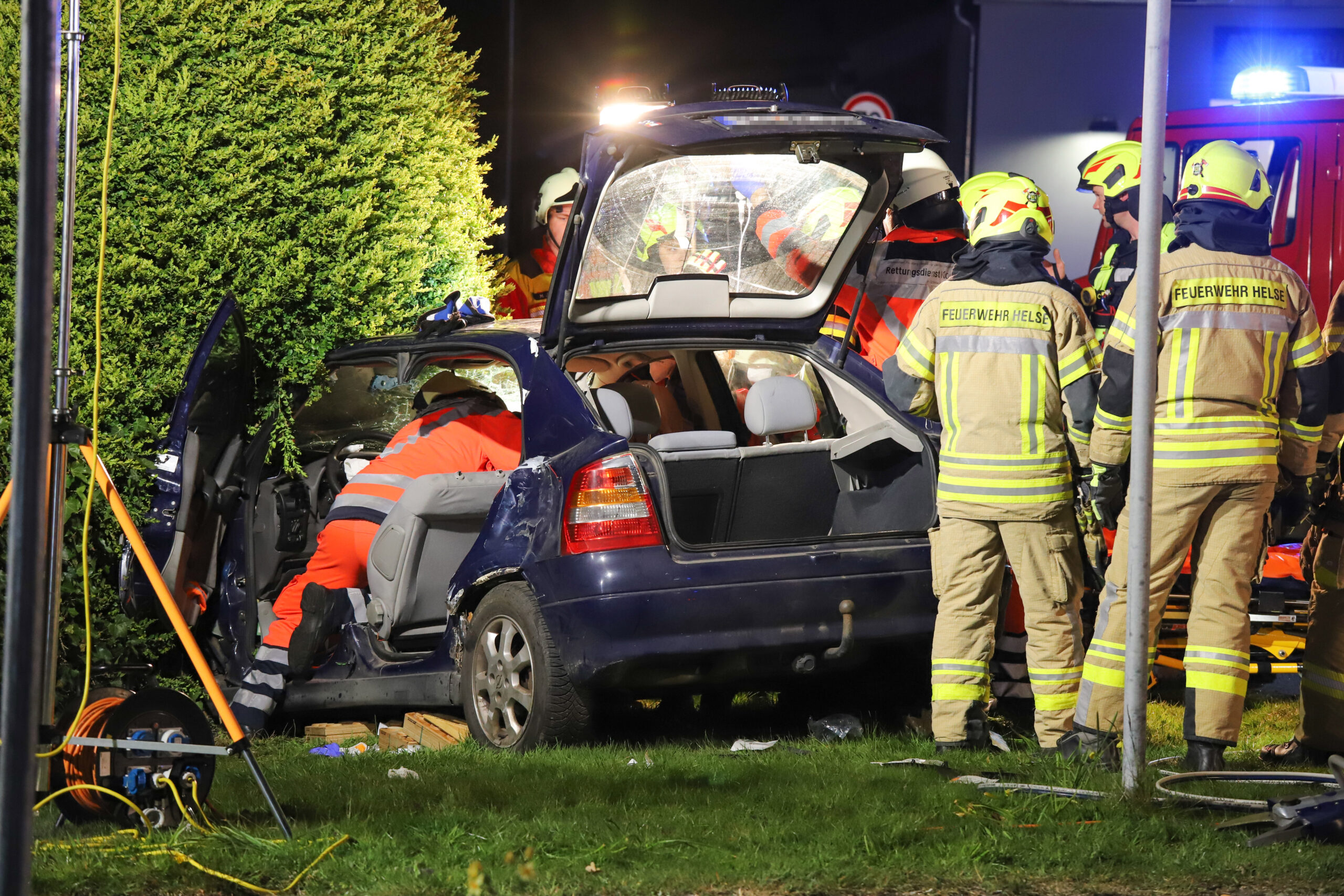 Feuerwehrmänner befreien die Schwerverletzten aus dem Opel.