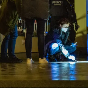 Eine Kripo-Beamtin sichert Blutspuren und Hülsen am Tatort in Hamburg.