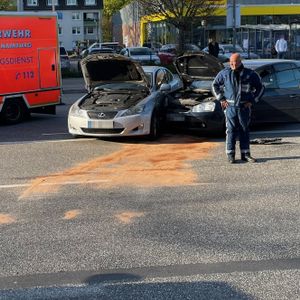Zwei Autos sind vorne ineinander gekracht, davor steht ein Polizist
