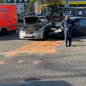 Zwei Autos sind vorne ineinander gekracht, davor steht ein Polizist