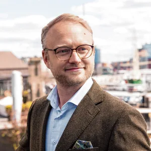 Michael Kruse steht am Hafen und guckt an der Kamera vorbei ins Nichts
