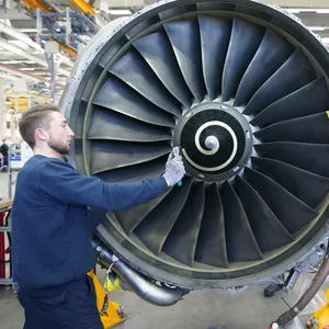 Ein Mitarbeiter schraubt an einer Flugzeugturbine in der