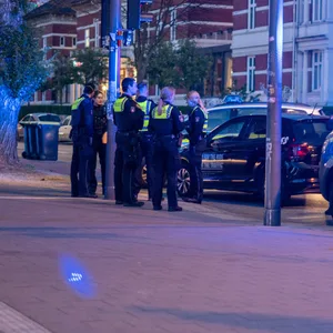 Polizeibeamte vor dem Mietwagen an der Weidenallee in Hamburg.