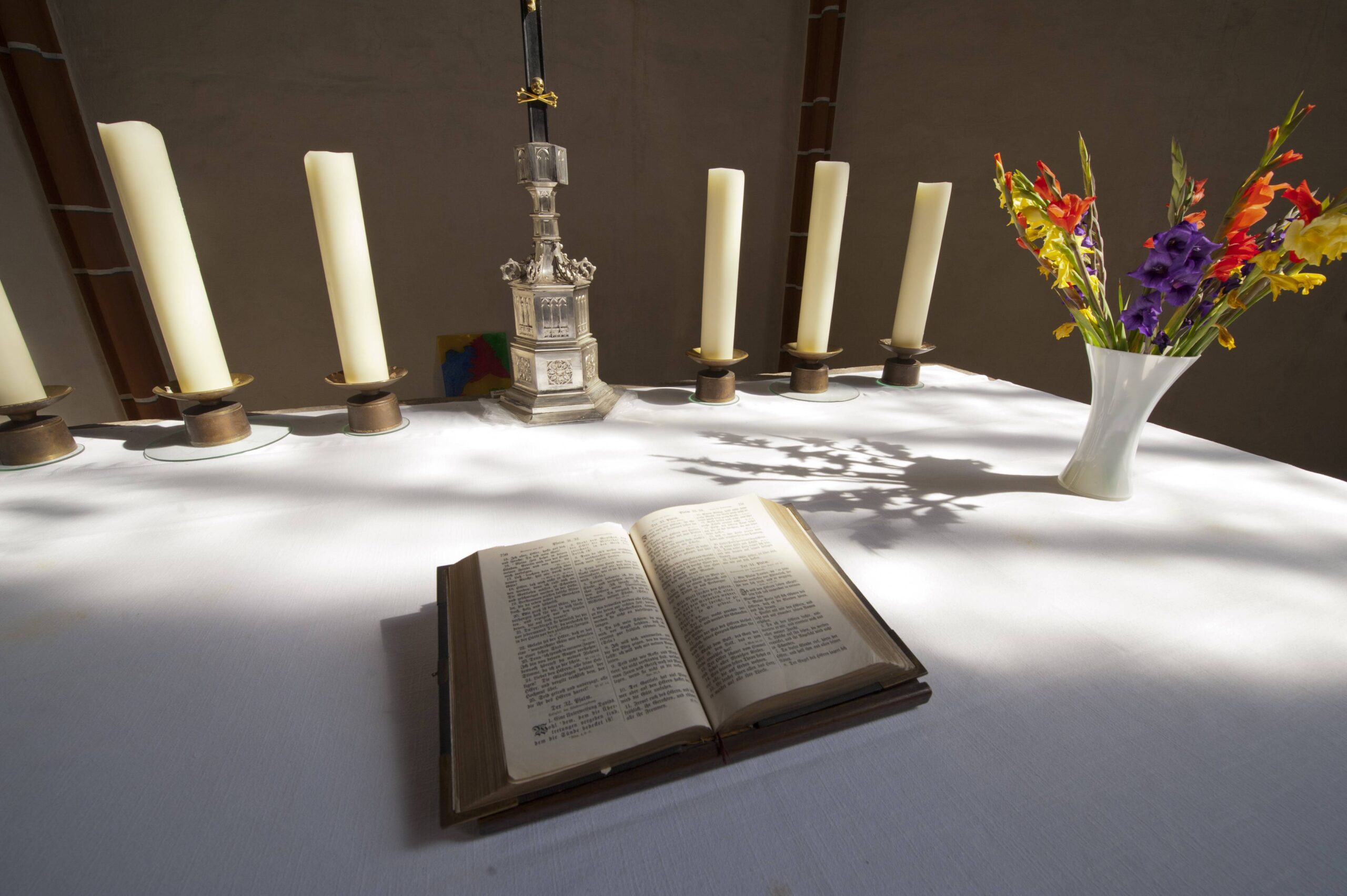 Bibel und Kerzen auf einem Altar.