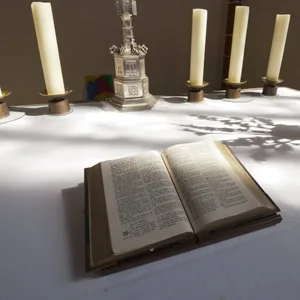 Bibel und Kerzen auf einem Altar.