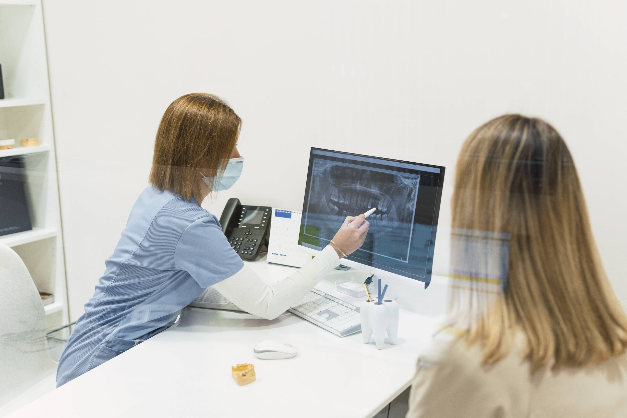 Ärztin in ihrer Praxis zeigt der Patientin eine Aufnahme auf dem Bildschirm.