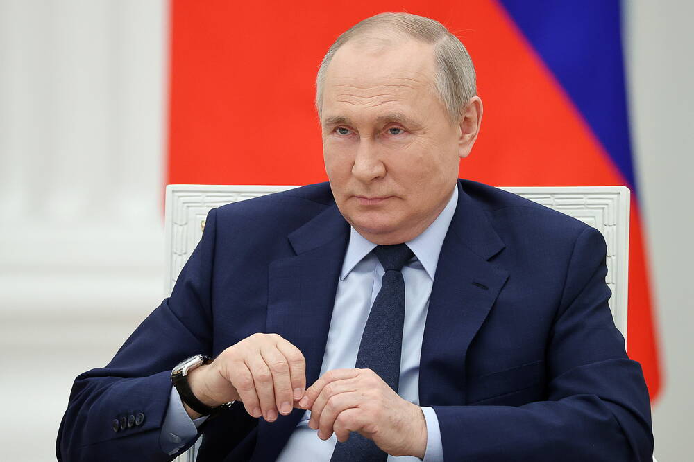 Putin sitzt auf einem Stuhl im Kreml