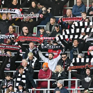 Eintracht Frankfurt Fans halten auf der Tribüne ihre Schals über den Köpfen