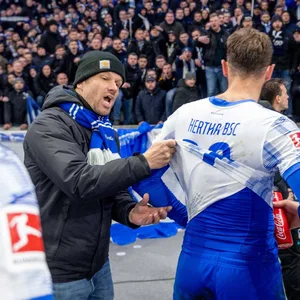 Ein wütender Hertha-Fan fordert einen Spieler dazu auf, sein Trikot auszuziehen