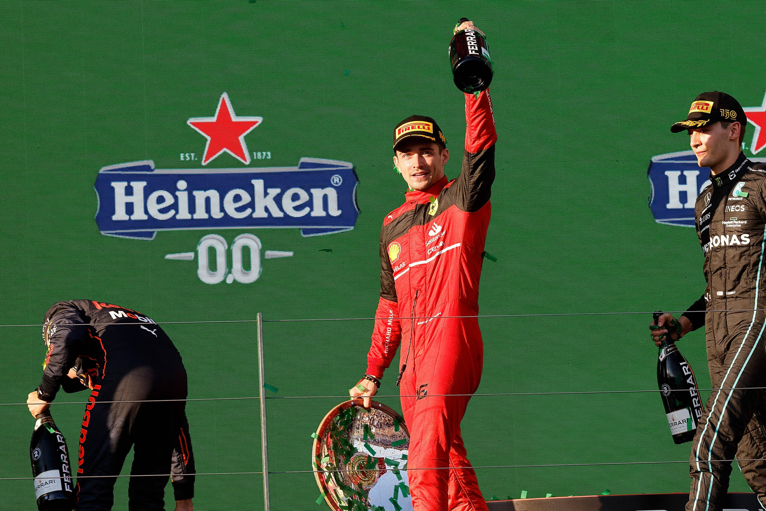 Formel 1 Rennfahrer Charles Leclerc hält eine Schampusflasche nach oben
