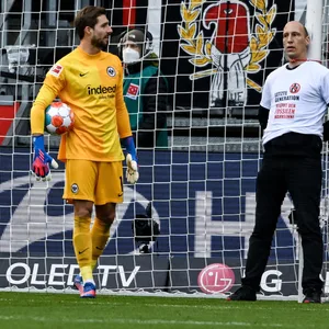 Ein Aktivist von „Letzte Generation“ am Frankfurter Torpfosten neben Torhüter Kevin Trapp