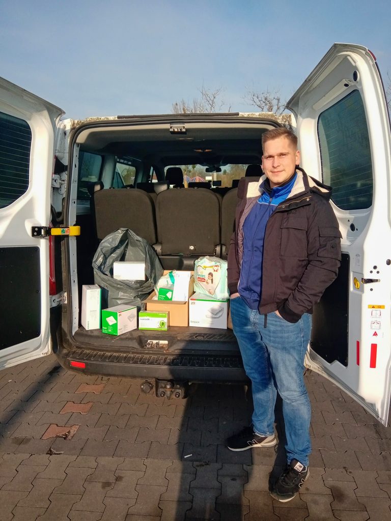 Viktorian Verny, Aktivist bei den Hamburger Linken, vor einem der beladenen Kleinbusse.