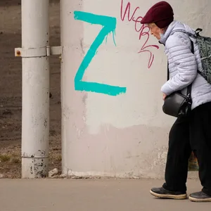 Russland, St. Petersburg: Eine Frau geht an Brückenpfeilern vorbei, die mit dem Buchstaben „Z“ bemalt sind. Er wurde zum Symbol des russischen Militärs.