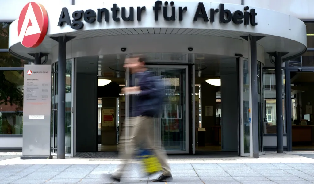 Symbolbild: Ein Mann geht in Hamburg an einer Agentur für Arbeit vorbei.