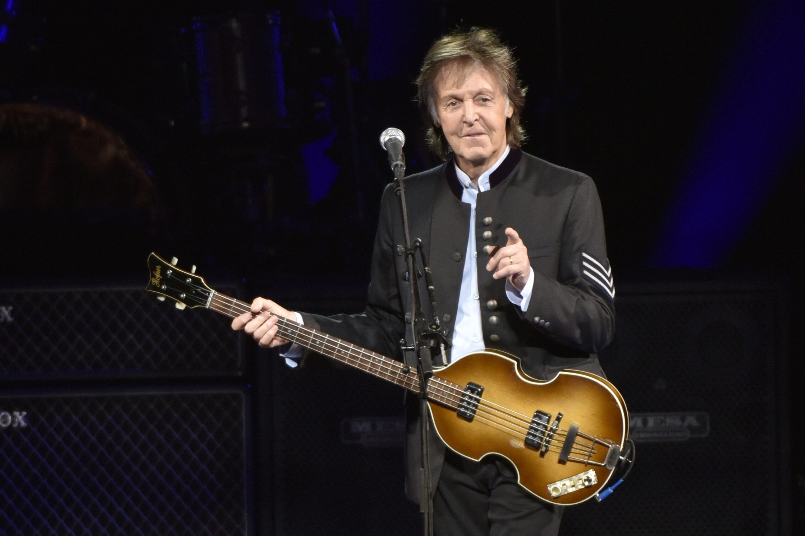 Paul McCartney mit Gitarre in der Hand - zeigt ins Publikum und lächelt