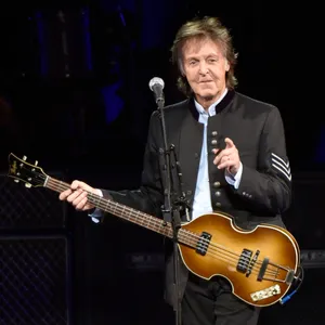 Paul McCartney mit Gitarre in der Hand - zeigt ins Publikum und lächelt