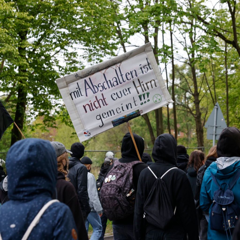 Demonstrierende halten ein Schild mit der Aufschrift „mit Abschalten ist nicht euer Hirn gemeint“