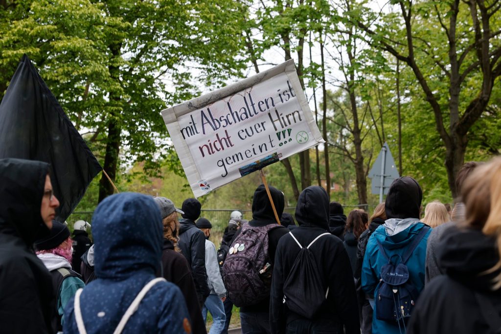 Demonstrierende halten ein Schild mit der Aufschrift „mit Abschalten ist nicht euer Hirn gemeint“