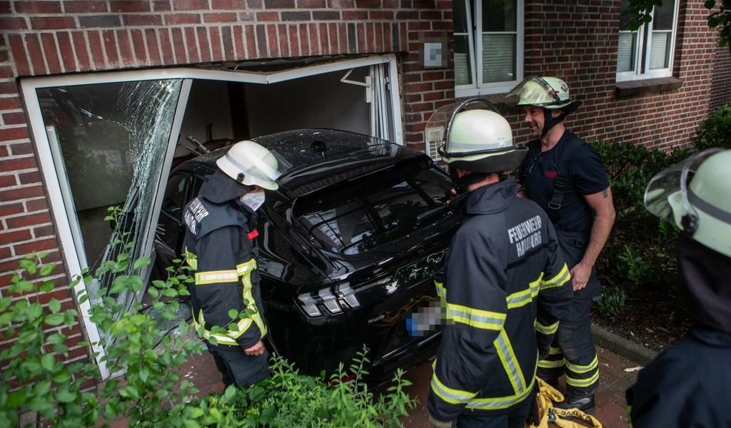 Ein schwarzes Auto steht im Hauseingang, Türen und Fenster sind völlig zerstört
