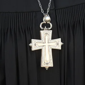 Ein Kreuz hängt über einem Talar.