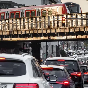 Zahlreiche Autos stehen an einer Ampel an der Sternbrücke, während dort eine Bahn drüber fährt
