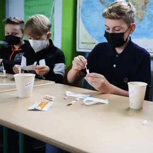 Schüler führen im Unterricht einen Corona-Schnelltest durch