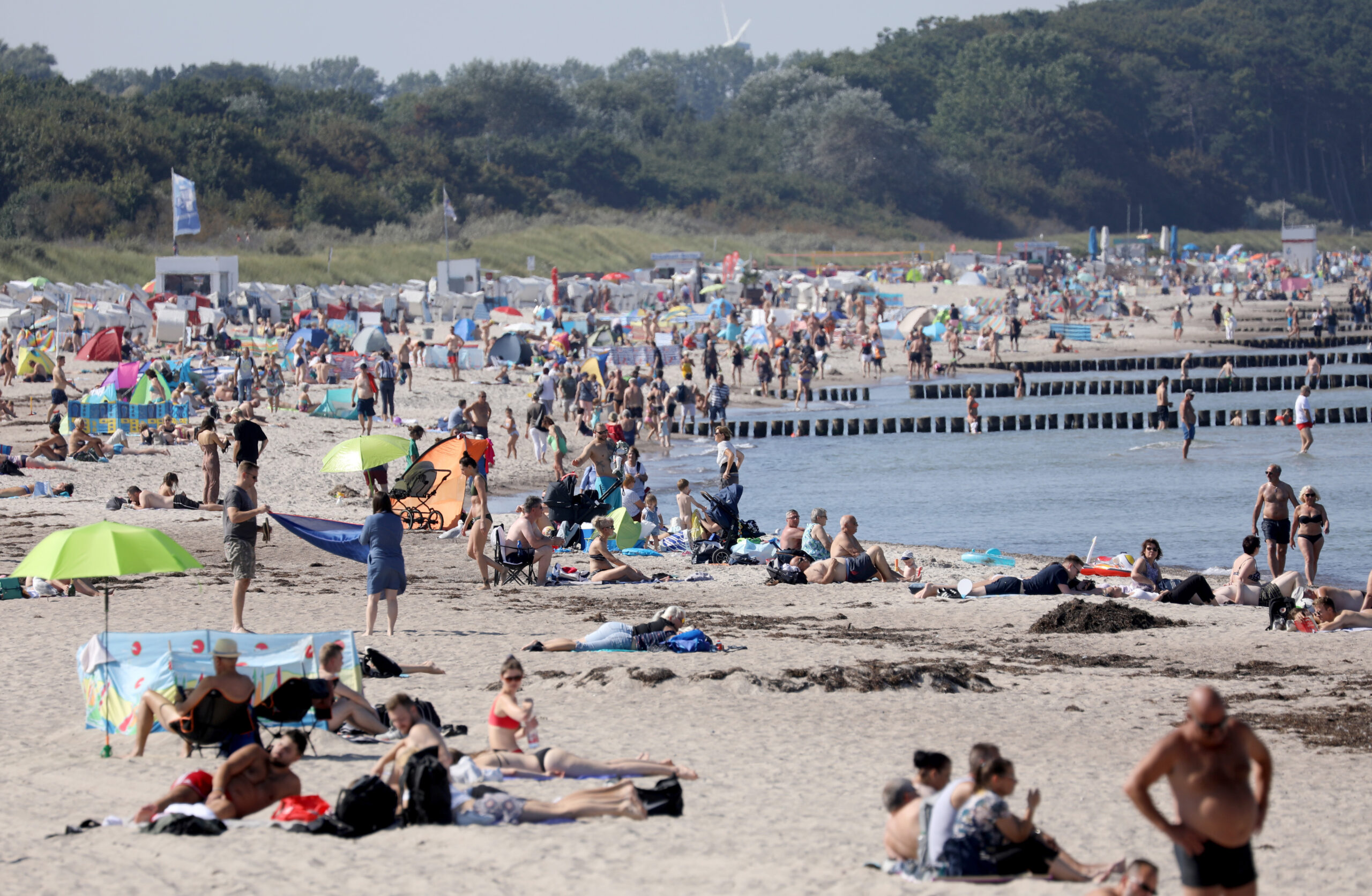 Viele Menschen liegen am Strand - auch wenn das Wetter besser sein könnte