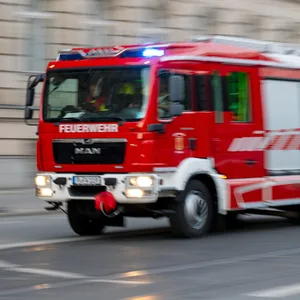Symbolbild: Ein Feuerwehrauto mit eingeschaltetem Blaulicht fährt zum Einsatz.