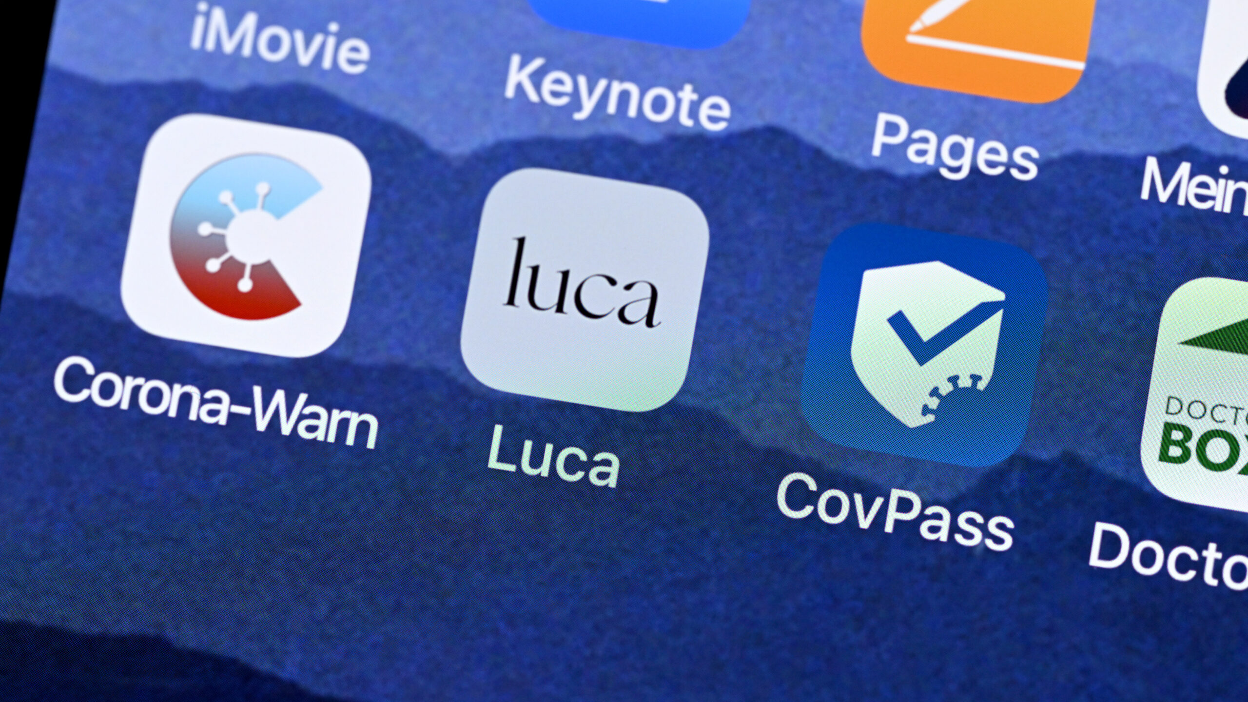 Das Startsymbol einer Luca-App ist neben den Symbolen von Corona-Warn-App und CovPass App auf einem Bildschirm eines Smartphones dargestellt.