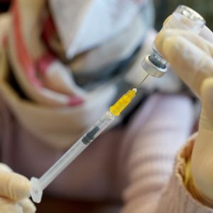 Eine medizinische Mitarbeiterin bereitet eine Corona-Impfung vor. Viele Hamburger:innen fragen sich, ob sie sich noch ein viertes Mal impfen lassen sollten.