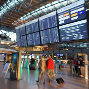 Fluggäste gehen mit ihrem Gepäck zum Check-in im Terminal 2 des Flughafens Hamburg Airport.