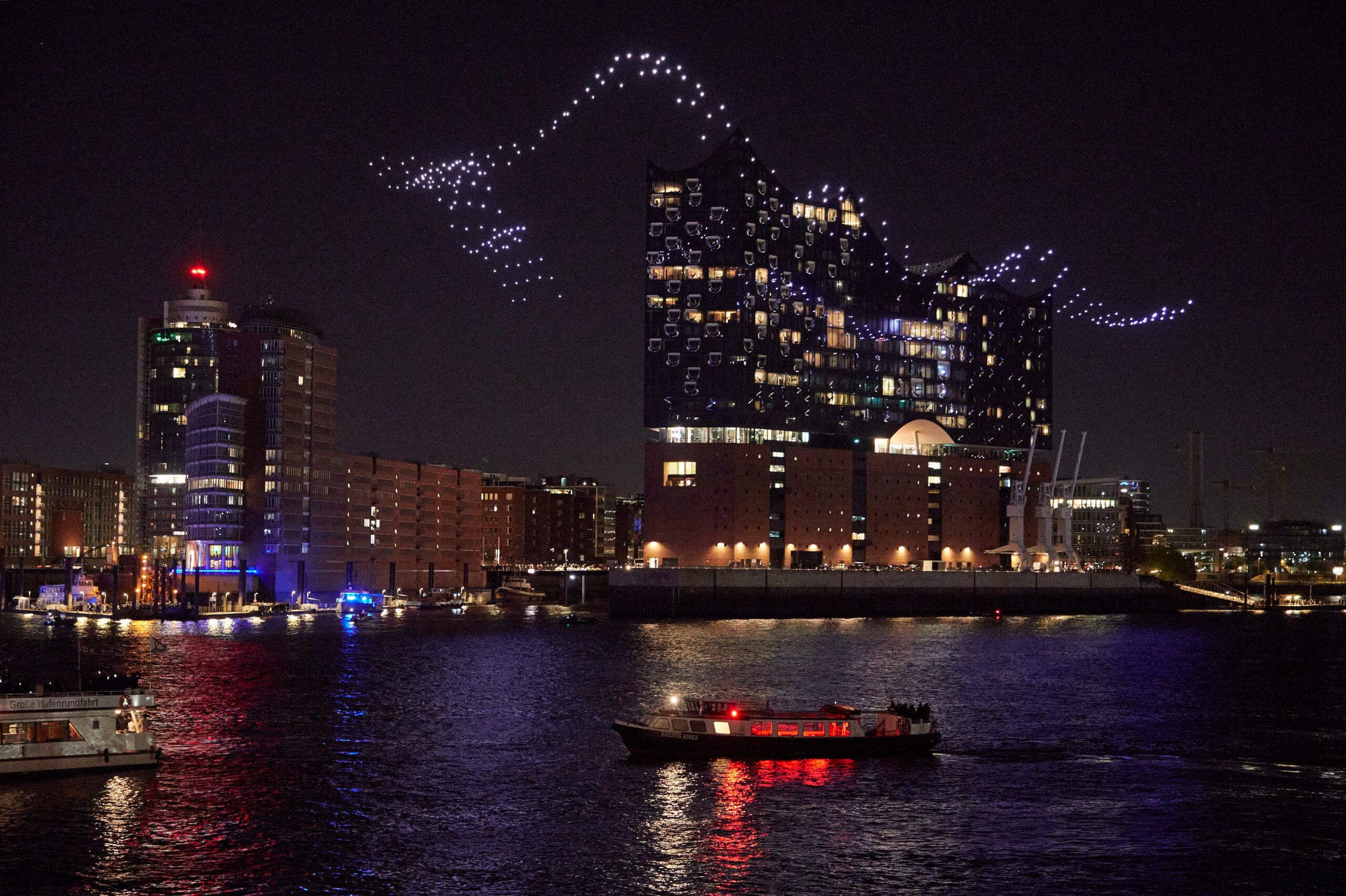 Beleuchtete Drohnen fliegen über der Elbe vor der Elbphilharmonie im Rahmen der Eröffnung des Musikfests Hamburg.