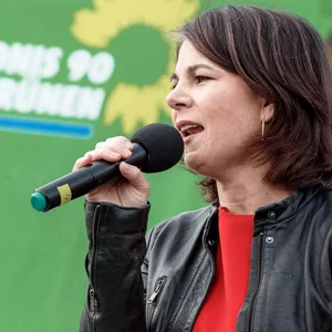 Annalena Barbock steht mit einem Mikrofon auf der Bühne.