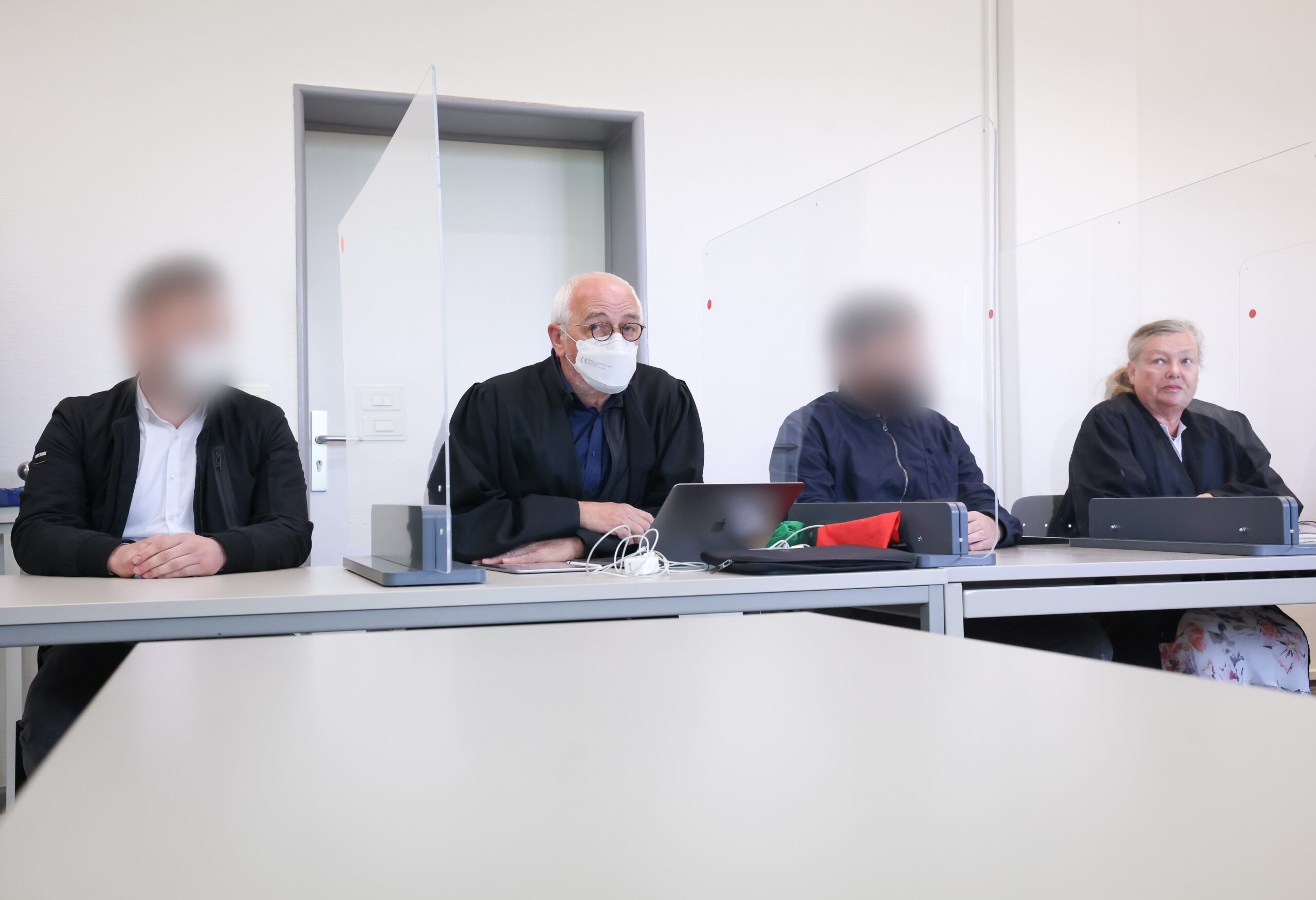Die zwei Angeklagten sitzen zu Beginn des Prozesses vor dem Amtsgericht Harburg neben ihren Anwälten.