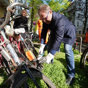 Hamburgs Umweltsenator Jens Kerstan flext ein Fahrradschloss eines Schrottfahrrads ab..