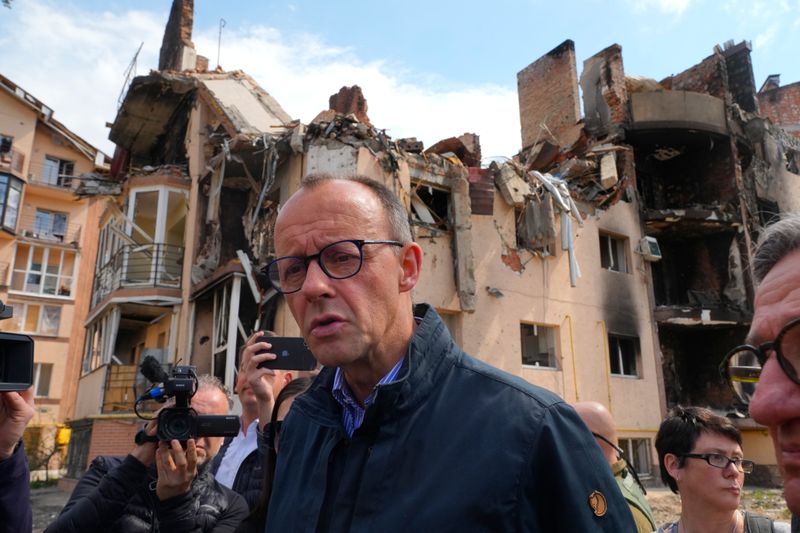 Der CDU-Vorsitzender Friedrich Merz macht sich ein Bild von der Zerstörung in Irpin.