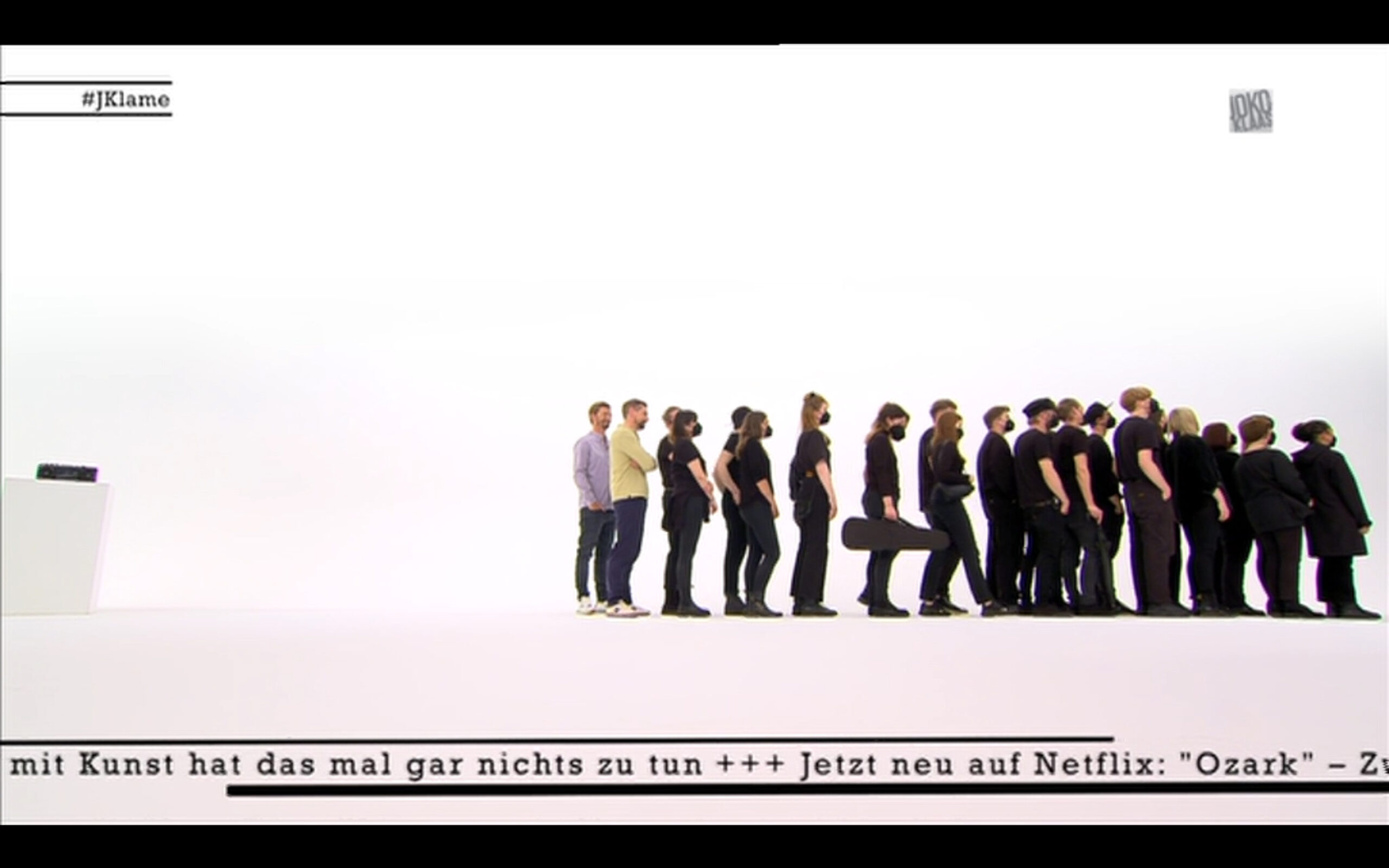 Screenshot der Sendung: Joko und Klaas stehen hinter vielen schwarz gekleideten Menschen
