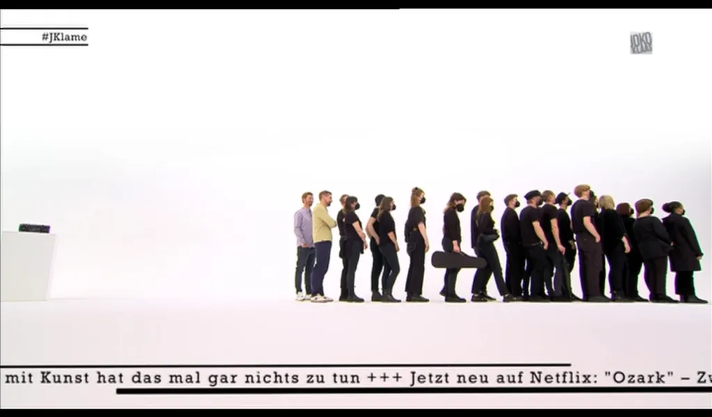 Screenshot der Sendung: Joko und Klaas stehen hinter vielen schwarz gekleideten Menschen