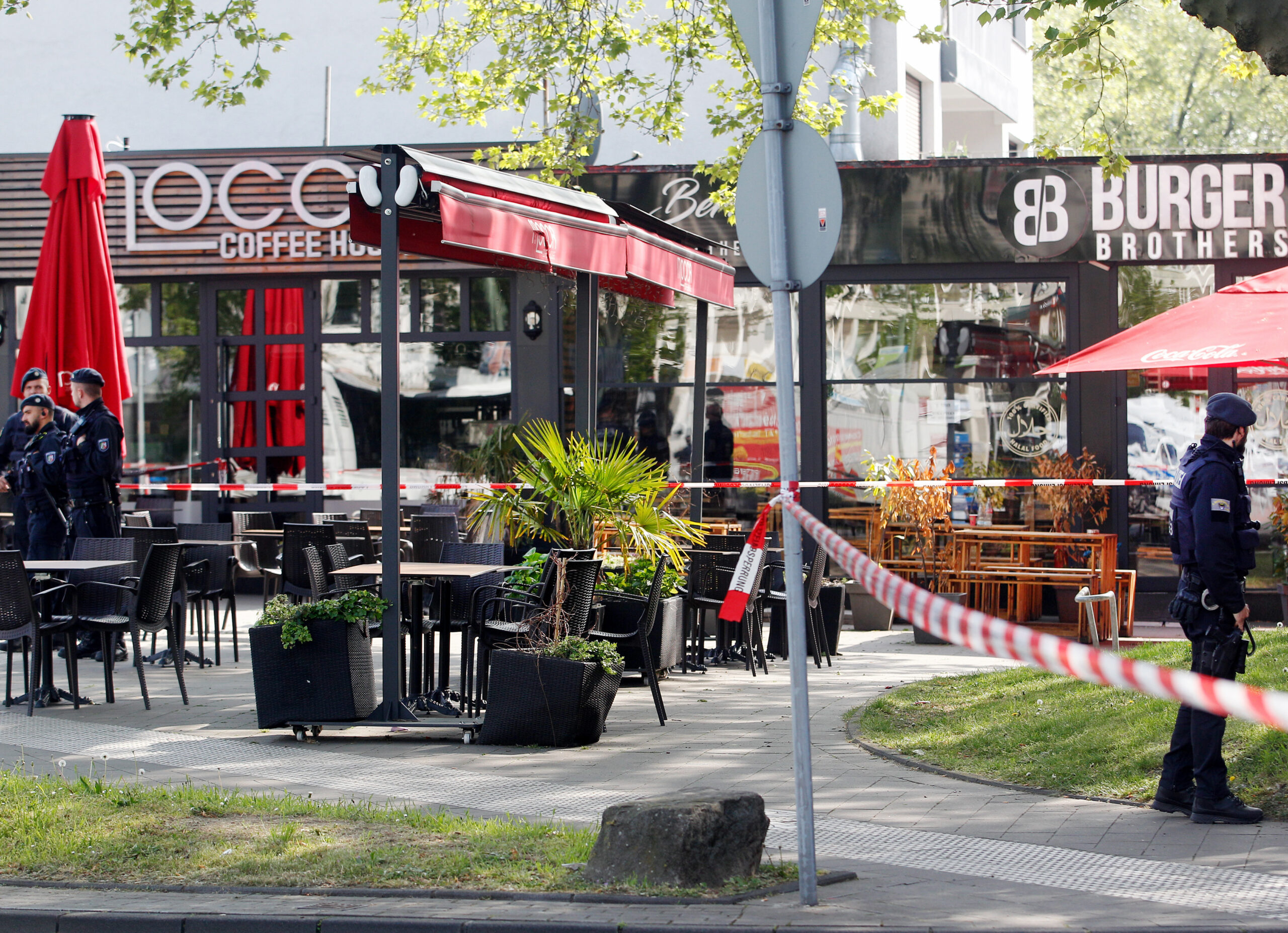 Polizisten haben einen Tatort am Marktplatz, eine Café-Bar, mit Flatterband abgesperrt. Bei Schüssen auf offener Straße sind am Mittwoch (4.5.2022) vier Menschen verletzt worden.