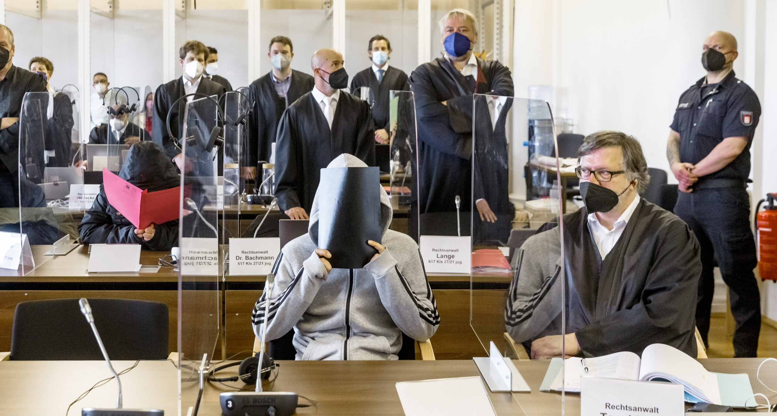 Zum Prozessauftakt verbargen die Angeklagten im Gerichtssaal ihre Gesichter.