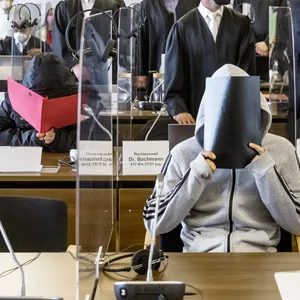 Zum Prozessauftakt verbargen die Angeklagten im Gerichtssaal ihre Gesichter.
