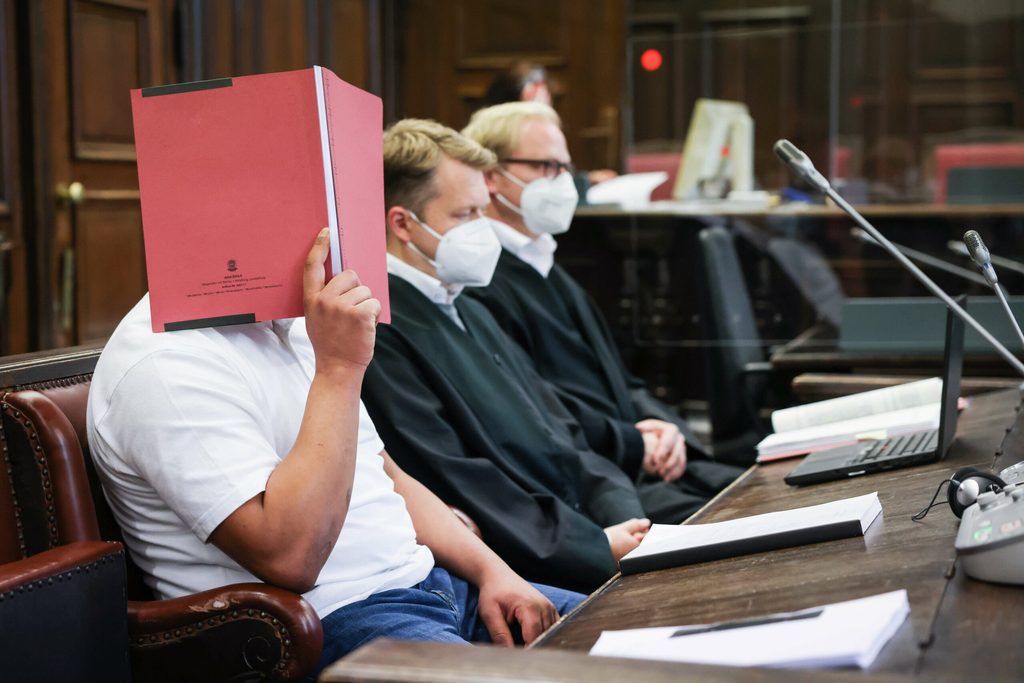 Der Angeklagte (links) sitzt im Strafjustizgebäude in Hamburg.
