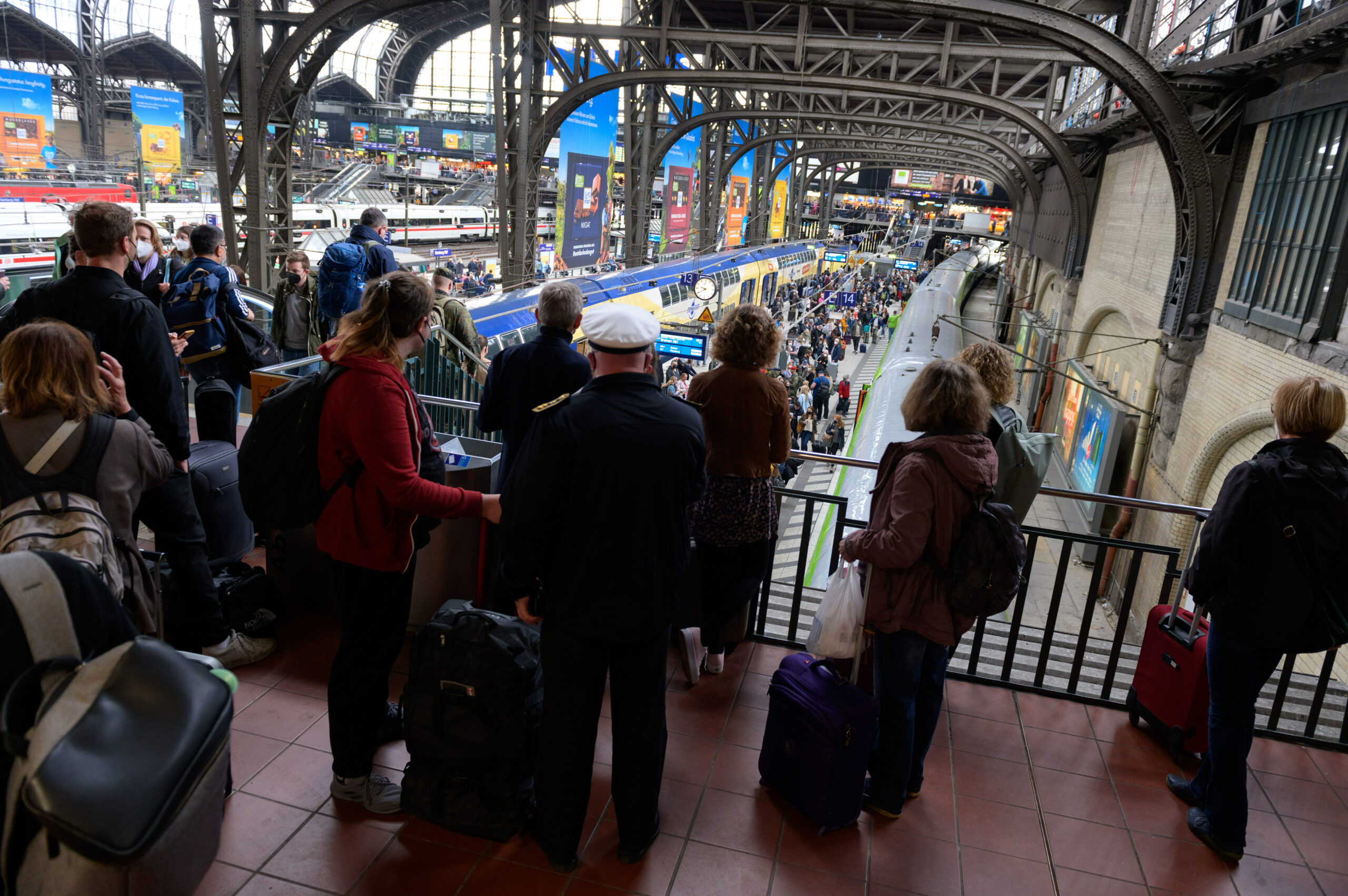 Zahlreiche Reisende stehen vor und auf einem Bahnsteig am Hamburger Hauptbahnhof.