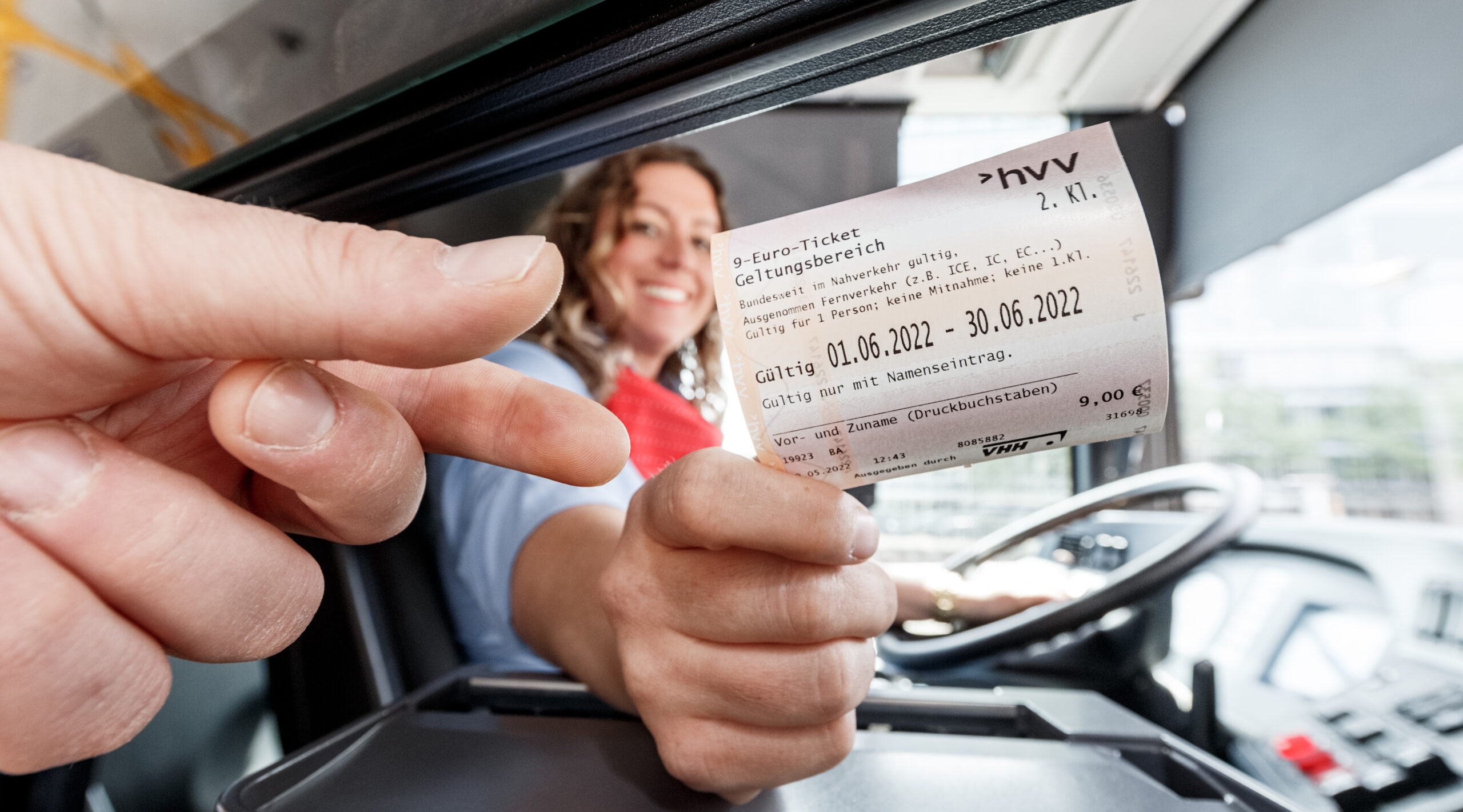 Symbolbild: HVV-Busfahrerin Miriam Kara gibt einem Kunden sein 9-Euro-Ticket.
