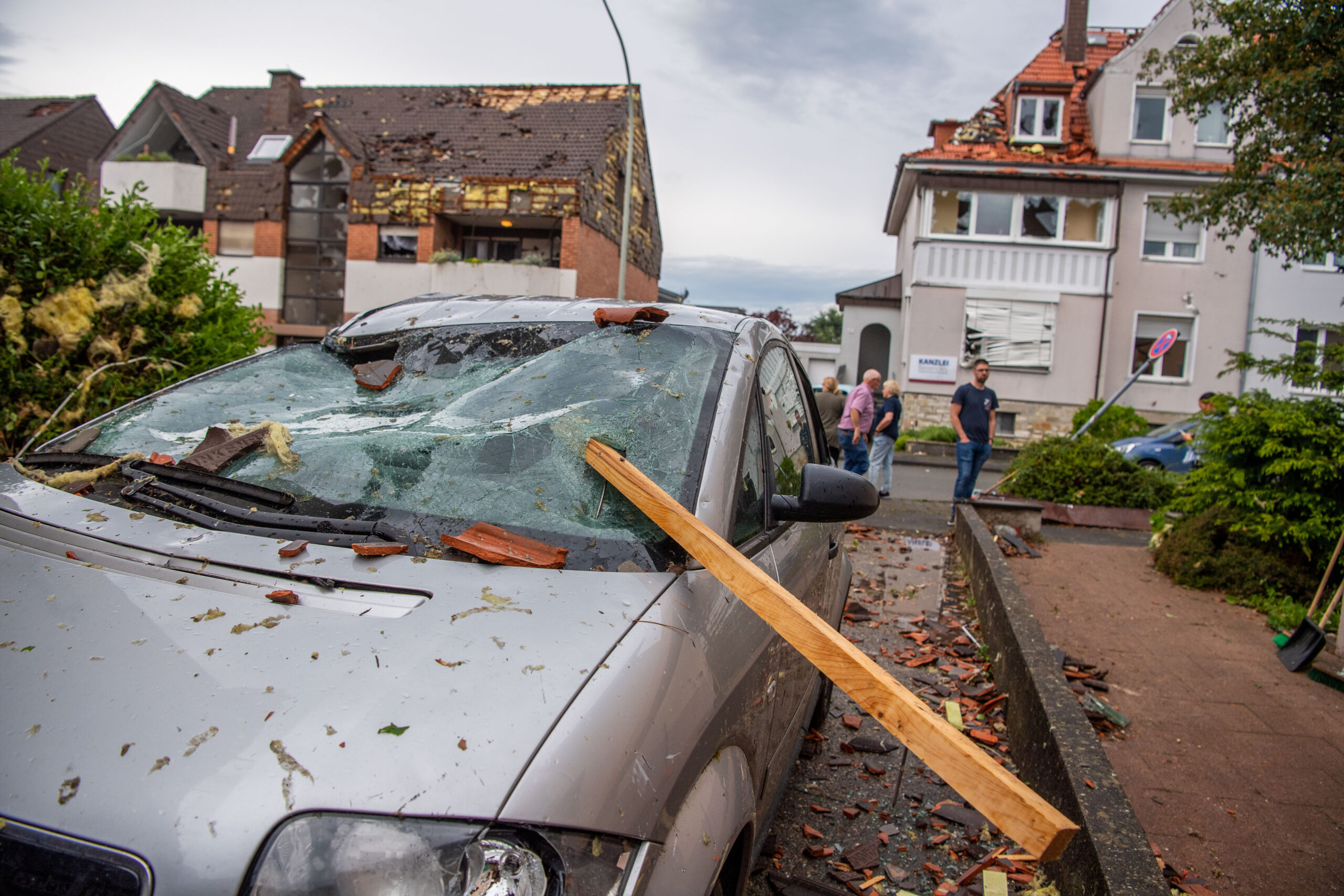 Eine Dachlatte steckt in der Windschutzscheibe eines Autos. In Paderborn hat das Unwetter große Schäden angerichtet.