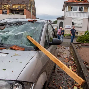 Eine Dachlatte steckt in der Windschutzscheibe eines Autos. In Paderborn hat das Unwetter große Schäden angerichtet.
