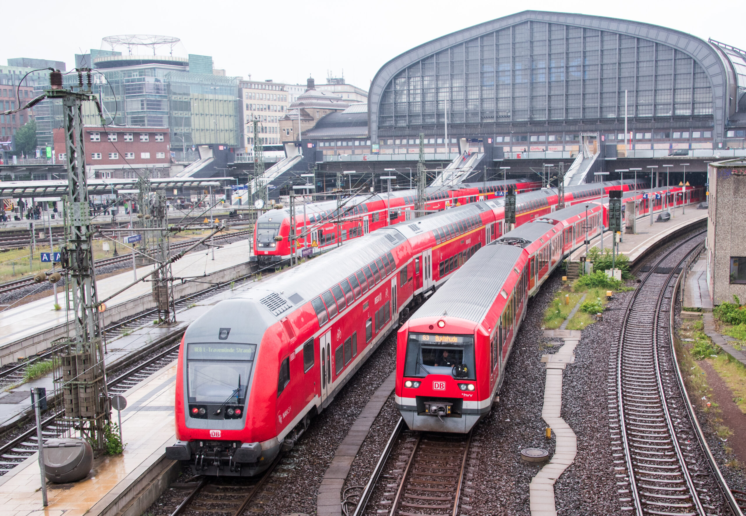 Züge der Regionalbahn und der S-Bahn stehen und fahren im Hauptbahnhof