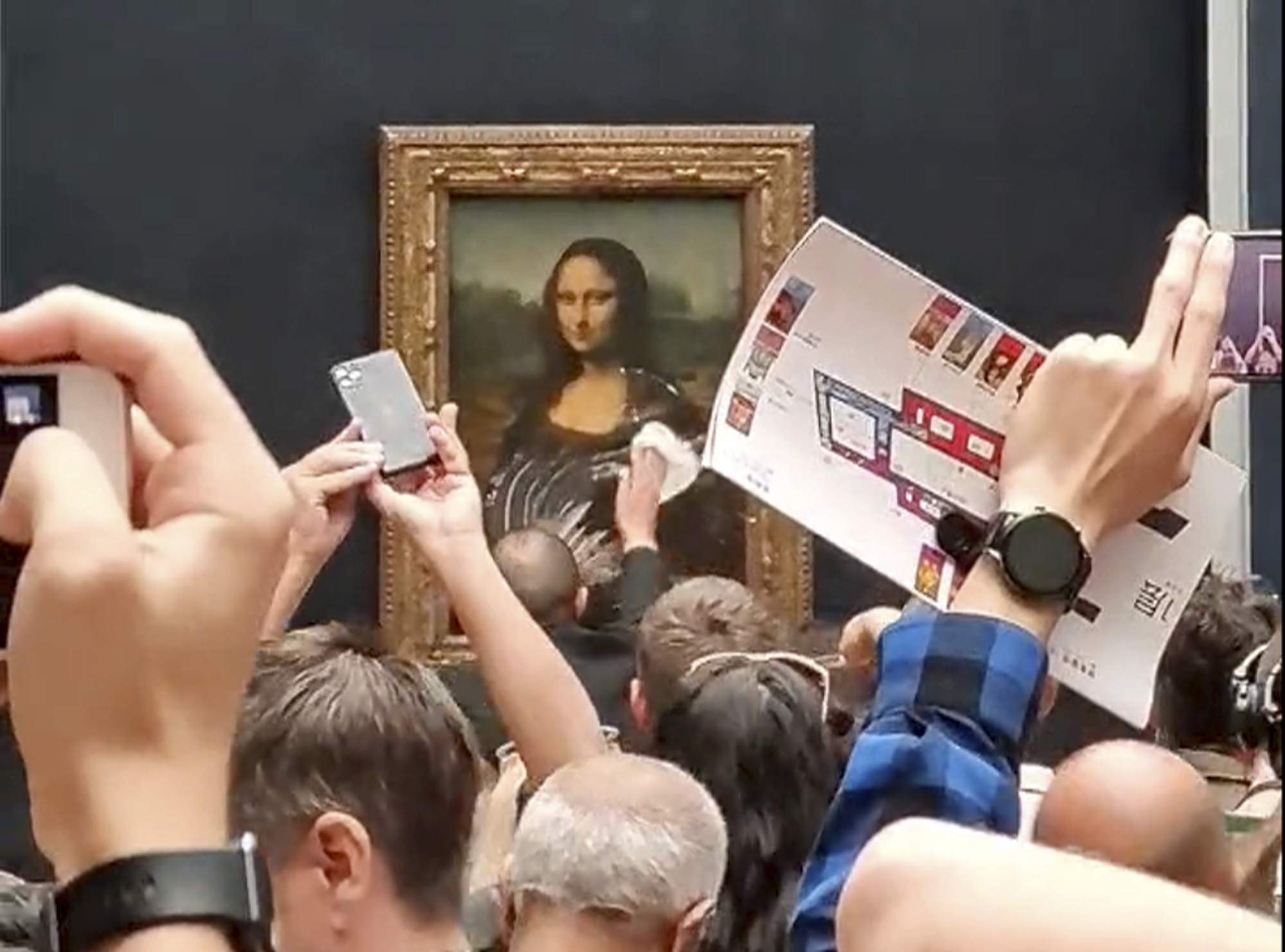 Ein Mitarbeiter des Louvre wischt den Sahnekuchen von der Vitrine, die die Mona Lisa im Louvre-Museum schützt.